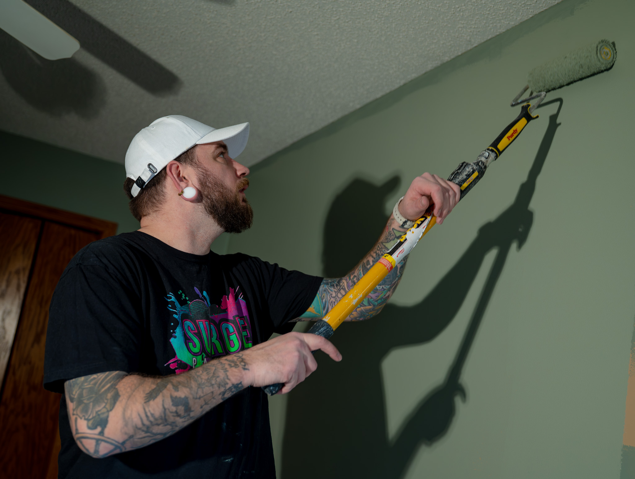 Surge Painting painter working on a green wall